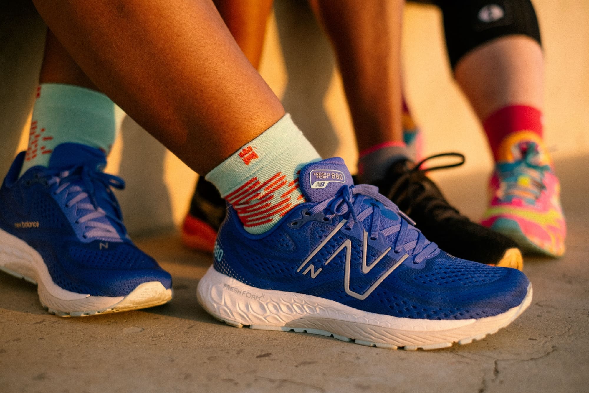 A close up photograph of a pair of mint and coral trainer half-crew socks.